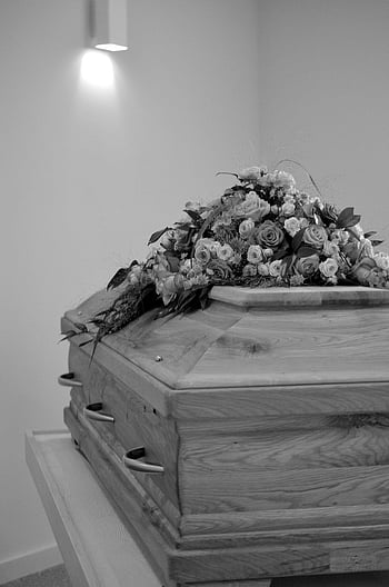grayscale photo, coffin, black-and-white image, wooden casket, adorned flowers, peaceful setting, funeral, memorial, death, mourning, tribute