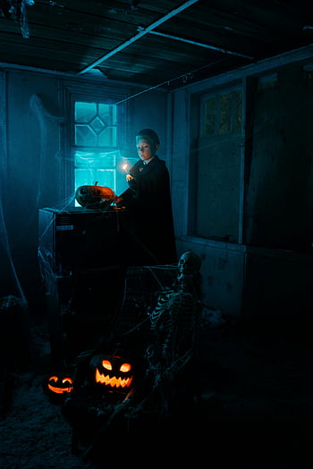 garçon avec match éclairé, pièce sombre, citrouilles d'halloween, squelette, atmosphère effrayante, faiblement éclairé, décorations d'halloween, scène effrayante, Cadre d'Halloween, thème d'halloween, la nuit d'Halloween