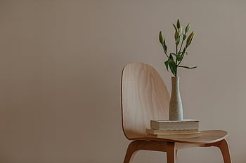 białe i zielone kwiaty, drewniane krzesło, Minimalistyczna konfiguracja, wazon, stos książek, wystrój wnętrz, proste wnętrze, nowoczesny design, układ kwiatowy, dekoracja domowa, biały wazon