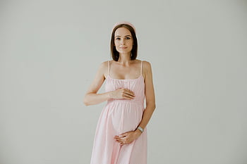 gestante, vestito rosa, mani sul ventre, sfondo bianco, foto di maternità, gravidanza, posizione del ventre, mamma in attesa, moda premaman, Fotografia di gravidanza