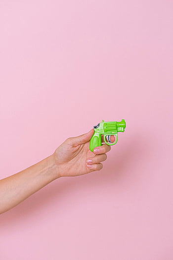 hånd, Plastpistol, Grønn leketøyspistol, levende rosa bakteppe, moro, fantasi, lite leketøy, leken, sterke farger, minimalistisk, fotografering