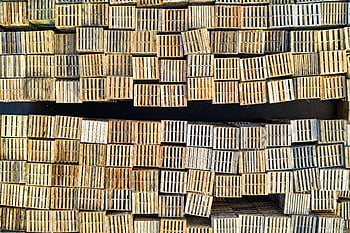 stacked wooden pallets, high angle shot, neatly stacked, outdoor warehouse, wooden pallets, industrial storage, pallet stack, warehouse setting, storage solution, logistics equipment, wooden crates
