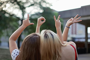 two women, hand signs, love symbol, friendship, summer setting, young women, outdoor photo, love gesture, hand gesture, summer friendship, two friends
