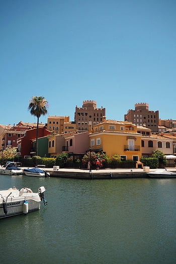 Port Saplaya, Alboraya, Valencia, Spain, colorful buildings, waterfront, scenic view, boats, palm tree, Mediterranean architecture, waterfront town