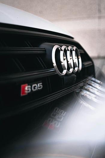 Audi emblem, close-up shot, Audi SQ5, vehicle design, sleek design, car emblem, detailed shot, Audi logo, car branding, luxury car, automotive design