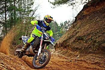 man riding dirt bike, blue and white dirt bike, motocross action shot, forest trail, biker speeding, motocross skill, intense motocross, dirt bike trail, motocross rider, forest motocross, dirt bike action