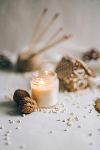 noix, bougie allumée, scène de vacances chaleureuse, aux chandelles, pain d'épice, ambiance hivernale sereine, décor de vacances, scène d'hiver, atmosphère festive, cadre confortable, décoration saisonnière