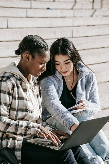 Studenci wieloetniczni, skoncentrowani studenci, schody kampusu, studiowanie razem, laptop, młode kobiety, otoczenie edukacyjne, różnorodni studenci, Badanie na świeżym powietrzu, Współpraca akademicka, życie w kampusie