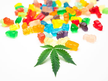 gummy bears, assorted colors, white background, cannabis leaf, vibrant gummies, scattered gummies, colorful candies, sweet treats, confectionery, edibles, marijuana leaf