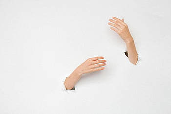 hands on white surface, close-up hands, creativity symbol, breakthrough concepts, white background, emerging hands, artistic expression, minimalist design, conceptual art, human hands, paper hole