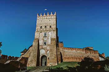 středověká hradní věž, stará kamenná věž, vysoké zdi, historické architektury, Vibrující modrá obloha, majestátní středověký hrad, hradní architektura, středověká věž, kamenná věž, Historická věž, Blue Sky Backdrop