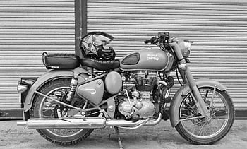 foto in scala di grigi, motociclo, Vintage Royal Enfield, motociclo parcheggiato, casco, design classico, fotografia in scala di grigi, campo reale, bici d'epoca, casco per moto, immagine in scala di grigi