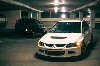 Mitsubishi Lancer, car park, dimly lit garage, sporty design, night, white Mitsubishi Lancer, black Mitsubishi Lancer, parking garage, car showcase, vehicle display, night photography