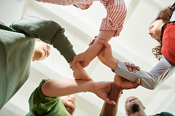 low angle view, five people, holding hands, unity circle, teamwork, cooperation, diverse group, symbolizing unity, group activity, human connection, collaboration
