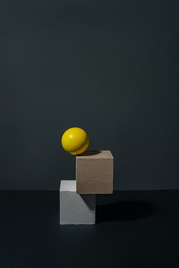 黄色の球体、 幾何学的なブロック、 ミニマリストスタイル、 芸術的な構成、 球体オブジェクト、 ブロックの上部、 暗い背景、 現代美術、 抽象的なデザイン、 シンプルな形状、 シャドープレイ