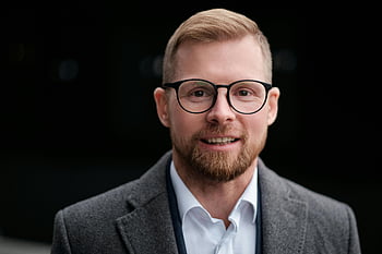 man, svart inramade glasögon, grå dräktjacka, le affärsman, skägg, närbild, professionell, porträtt, formell klädsel, självsäker, glasögon