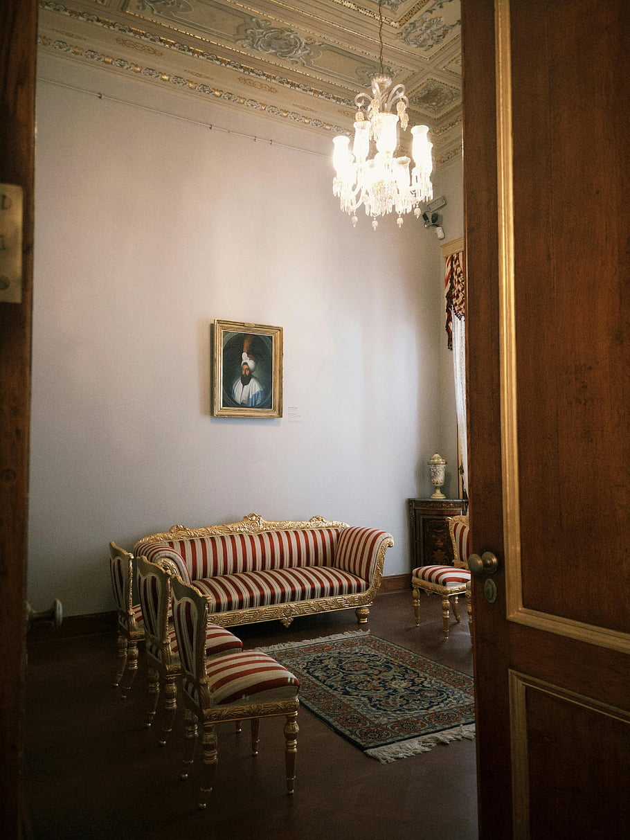 elegantní vintage obývací pokoj, lustr, starožitný nábytek, klasický obývací pokoj, Vintage Charm, pruhovaná pohovka, ozdobený koberec, Vzhled interiéru, vinobraní výzdoba, starožitný výzdoba, Elegantní interiér