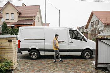 delivery man, opening van, suburban neighborhood, home delivery, white van, residential area, delivery service, man in uniform, van driver, residential delivery, suburban delivery