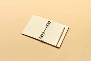 béžová barevná tužka, prázdný béžový zápisník, Otevřený spirálový notebook, tužka na zápisníku, béžové pozadí, dostatek prostoru pro kopie, minimalistický design, papírnické zboží, kreativní pracovní prostor, plochá laická fotografie, neutrální tóny