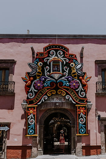 colorful decoration, building facade, vibrant decorated, San Miguel de Allende, Mexico, Meson San Ignacio, floral design, architectural detail, cultural art, traditional decor, festive ornamentation