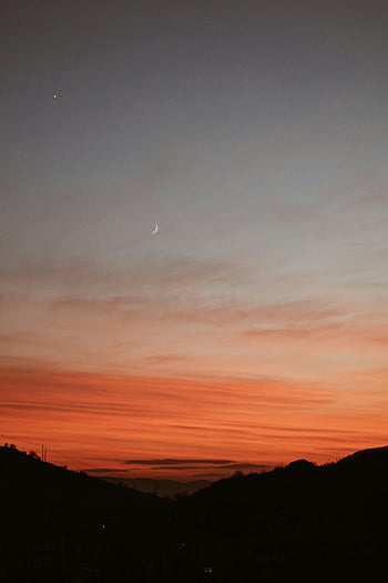 sunset, silhouette of mountains, orange sky, crescent moon, dramatic sunset, evening sky, mountain range, twilight, natural landscape, scenic view, dusk