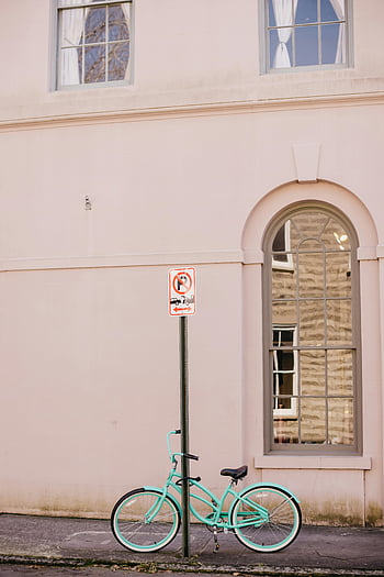 mint bicycle, pastel wall, no parking sign, white concrete building, urban scene, street photography, cityscape, architectural details, vintage bike, outdoor setting, signage