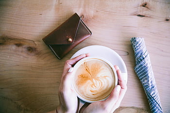 káva, latte, bílý keramický pohár, útulná kavárna, teplý nápoj, káva umění, dřevěný stůl, Ruce držící pohár, latte art, kávový šálek, Útulné nastavení