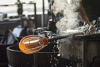 glass blowing, artisan, craftsmanship, black shirt, glass rod, skilled, intricate process, steam, molten glass, workshop, artistry