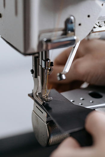 Industrienähmaschine, schwarzer Lederstoff, Handwerkskunst, Nähprozess, detailliertes Bild, Ledernähen, Nähmaschine im Einsatz, Lederhandwerk, Nähmaschinendetails, Lederarbeit, Nähmaschine Nahaufnahme