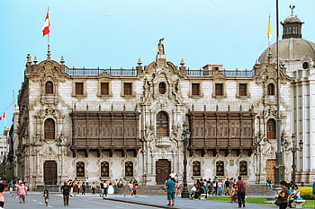 Archbishops Palace of Lima, ornate facade, Archbishop's Palace, Lima, people walking, historic building, colonial architecture, Peru, cityscape, tourists, flags
