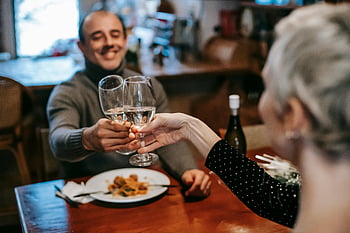 glückliches Paar, klirrende Weingläser, romantisches Abendessen, Gemütliches Restaurant, Wein Toast, Abendessen genießen, Paar im Restaurant, romantische Atmosphäre, Weingläser, Abend Verabredung, gemütliche Einstellung