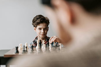 Chlapec hraje šachy, mladý kluk, šachovnice, vnitřní šachy, soustředěný chlapec, šachová hra, vnitřní činnost, šachové figurky, Strategická hra, Koncentrace chlapce, Šachový hráč