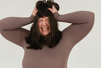 young woman, expressing frustration, hands on head, studio shoot, white background, rumpling hair, closed eyes, emotional expression, body positive, plus size, studio photography