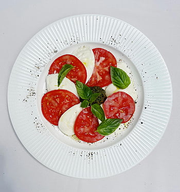 สลัด Caprese, มะเขือเทศ, ชีสมอสซาเรลล่า, โหระพา, แผ่นเซรามิกสีขาว, อร่อย, ชุบอย่างหรูหรา, ส่วนผสมสด, อาหารอิตาเลี่ยน, มังสวิรัติ, รับประทานอาหารเพื่อสุขภาพ
