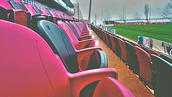 empty sports stadium, colorful seats, sports field, event themes, stadium seating, day time, sports venue, empty seats, outdoor stadium, sports arena, event location