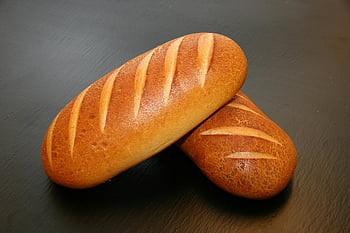 brown baked breads, freshly baked loaves, crispy crust, food photography, still life photography, close-up, table, two loaves, ideal food, baked goods, artisan bread