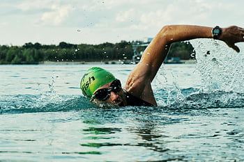 swimming, male swimmer, green cap, goggles, open water race, body of water, outdoor swimming, competitive swimming, water sport, athletic swimmer, open water