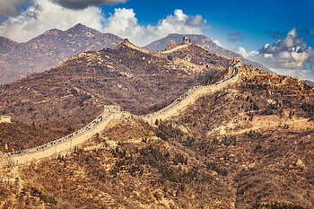 Great Wall of China, mountainous terrain, blue sky, scenic view, historic landmark, ancient architecture, Chinese history, cultural heritage, travel destination, natural landscape, outdoor adventure