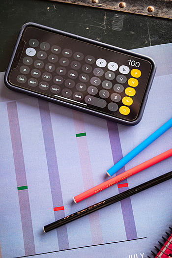 smartphone, calculator app, colored pencils, graph paper, creative workspace, top view, smartphone calculator, workspace setup, multi-colored pencils, graphing tools, digital calculator