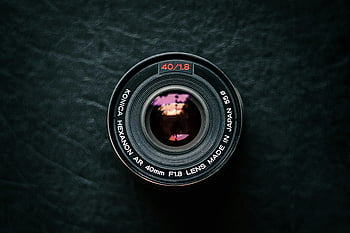kamerové čočky, černý povrch, Vintage Konica Hexanon, pohled shora, texturovaný tmavý povrch, 40 mm F1,8, vyrobeno v Japonsku, fotografické vybavení, příslušenství fotoaparátu, fotografování objektivů, tmavé pozadí
