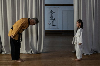martial arts instructor, bowing, student, young girl, martial arts uniform, karate instructor, respect, traditional martial arts, dojo, cultural respect, martial arts training