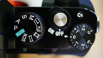 camera mode, control dials, macro shot, black electric device, camera settings, auto mode, SCN mode, ON OFF switch, camera controls, close-up photography, camera interface