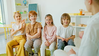 kids sitting on chair, cheerful children, clapping hands, lively classroom, group of children, classroom setting, children clapping, classroom activity, kids in classroom, children sitting, classroom environment