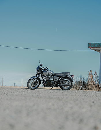 klasszikus motorkerékpár, parkolt motorkerékpár, kikövezett út, tiszta ég, nyugodt kültéri környezet, vintage kerékpár, szabadtéri jelenet, motorkerékpár -tervezés, klasszikus formatervezés, országúti, tiszta idő