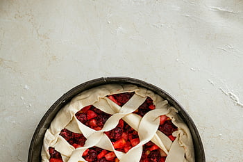 uncooked pie, cherry pie, lattice crust, unbaked pie, floured surface, overhead view, pie crust, baking preparation, homemade pie, pie filling, pie dish