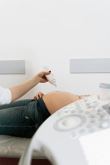 pregnant woman, ultrasound exam, medical clinic, applying gel, belly, ultrasound machine, pregnancy, medical procedure, healthcare, examination, clinic setting