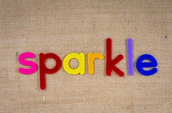 farbenfrohe Ausschnitte, Wort funkeln, lebendige Filzbuchstaben, strukturierter Sackleinen-Hintergrund, Farbkontrast, Kreativität, Filzbriefe, Sackleinen-Hintergrund, bunte Buchstaben, funkelndes Wort, leuchtende Farben