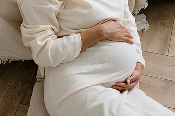 pregnant woman, belly, white dress, serene moment, cozy, close-up, maternity, pregnancy, motherhood, comfort, anticipation