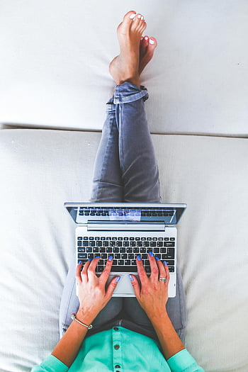 Frau tippen, Laptop, Draufsicht, Heimarbeit, Entspannung zu Hause, moderner Lebensstil, von zu Hause aus arbeiten, Gelegenheitsarbeit, Bequeme Arbeit, Innenministerium, Barfußarbeit