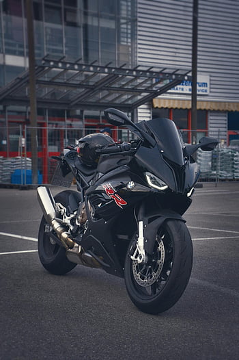 black motorcycle, BMW S1000RR, sports bike, city environment, dynamic shot, parked motorcycle, urban setting, black BMW, motorcycle photography, cityscape background, sportbike design